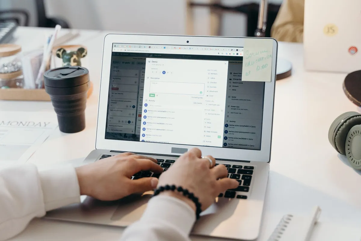 En person som jobber på laptop i et lyst kontor.