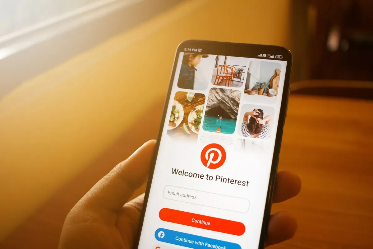 En person holder en mobil med Pinterest-appen åpen.